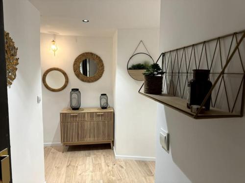 un couloir avec un miroir mural et une table dans l'établissement Duplex rénové comme Neuf à Aix-en-Provence, à Aix-en-Provence