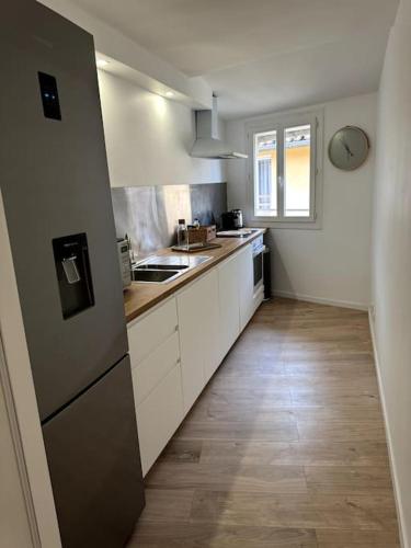 une cuisine avec des armoires blanches et un plancher en bois dans l'établissement Duplex rénové comme Neuf à Aix-en-Provence, à Aix-en-Provence