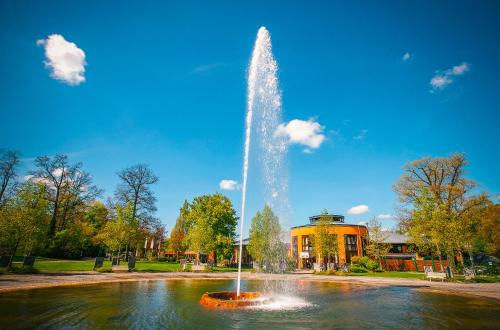 a fountain in the middle of a pond at Vienna House Easy by Wyndham Bad Oeynhausen in Bad Oeynhausen