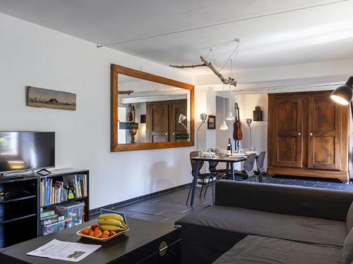 a living room with a couch and a table with a bowl of fruit at Apartment Grangettes-1 by Interhome in Noville