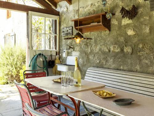 a kitchen with a table with chairs and a bottle of wine at Apartment Grangettes-1 by Interhome in Noville