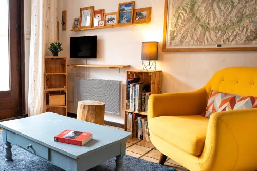 een woonkamer met een gele bank en een salontafel bij Jour De Peuf in Champagny-en-Vanoise