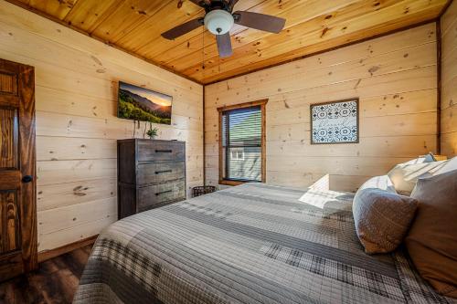 a bedroom with a bed and a ceiling fan at Back In Black in Pigeon Forge