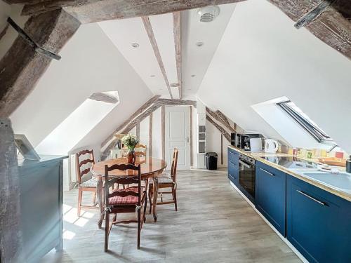 une cuisine avec une table et une cuisine avec des armoires bleues dans l'établissement Le Giuseppe - Nid central, à Compiègne