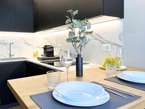 drewniany stół z płytami i kieliszkami do wina w obiekcie Jacuzzi Luxury Apartment in the Town Centre w Turynie