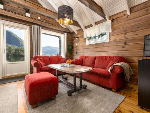 a living room with a red couch and a table at Holiday Home Strandbu by Interhome in Viksdalen