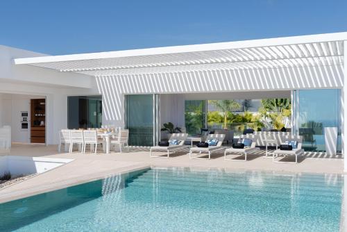 eine Villa mit einem Pool und einem Essbereich in der Unterkunft KARAT Villa Splendida in Playa Paraiso