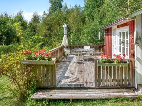 a wooden deck with a table and chairs on it at Holiday Home Stenfors by Interhome in Tingsryd