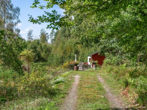 a dirt road in front of a red barn at Holiday Home Stenfors by Interhome in Tingsryd
