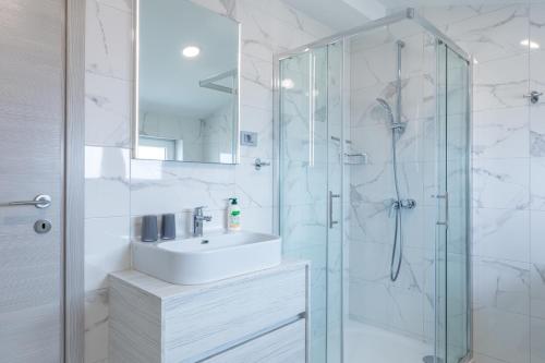 ein Badezimmer mit Waschbecken und Glasdusche in der Unterkunft The View in Crikvenica