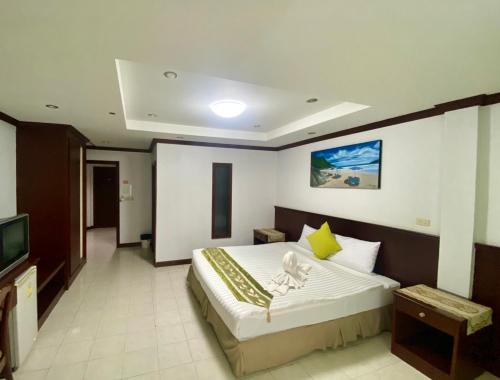 a bedroom with a large bed and a television at Sue@Cozy Guesthouse in Kata Beach