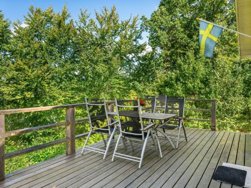 a deck with two chairs and a table and a flag at Holiday Home Gaslunda by Interhome in Olofström