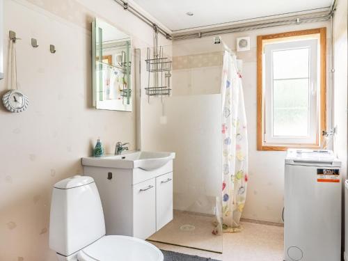 a bathroom with a toilet and a sink and a window at Holiday Home Gaslunda by Interhome in Olofström