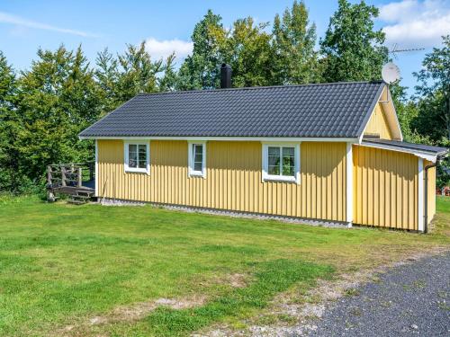 a yellow house with a yard at Holiday Home Gaslunda by Interhome in Olofström