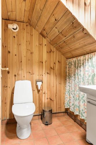 a bathroom with a toilet and wooden walls at Holiday Home Svenstorp by Interhome in Ryssby