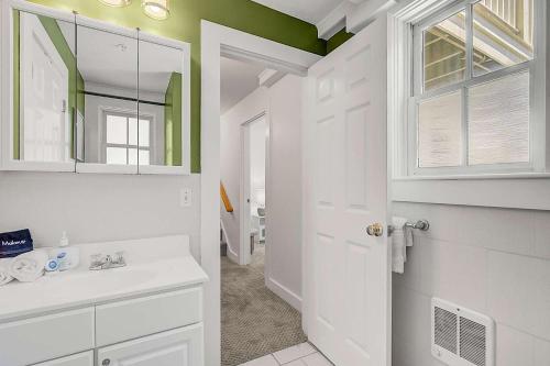 Un baño blanco con lavabo y espejo. en Oasis on Commercial Street w Balcony, en Provincetown
