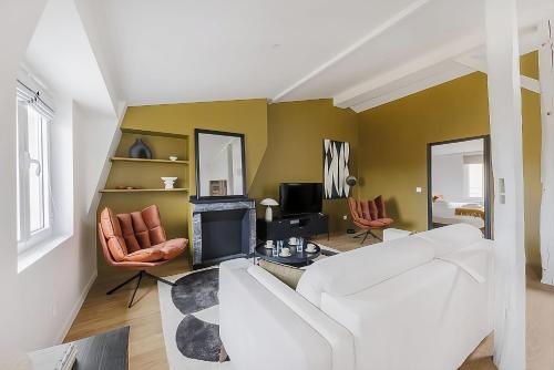 un salon avec un canapé blanc et une cheminée dans l'établissement 5 Amazing View Tour Eiffel Invalide Bon marché, à Paris