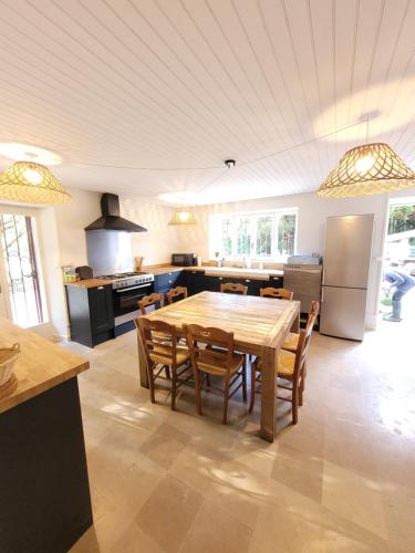 une grande cuisine avec une table et des chaises en bois dans l'établissement La maison du lac, à Vions