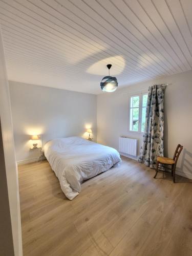 une chambre avec un lit blanc et une fenêtre dans l'établissement La maison du lac, à Vions