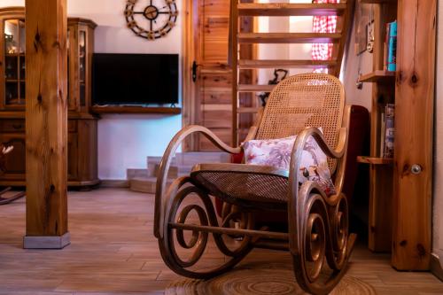 a wooden rocking chair sitting in a living room at Wellness hiša Jelenov Grič in Mala Nedelja