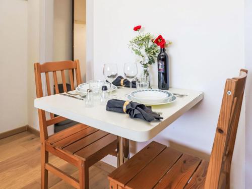 een witte tafel met glazen en een fles wijn bij Apartment Rosablanche D35 by Interhome in Siviez