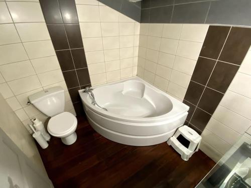 La salle de bains est pourvue de toilettes et d'une grande baignoire blanche. dans l'établissement Villa spacieuse -Vue exceptionnelle- Piscine, à Saint-Romain-de-Lerps