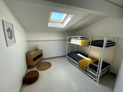 Cette chambre mansardée comprend des lits superposés et une lucarne. dans l'établissement Villa spacieuse -Vue exceptionnelle- Piscine, à Saint-Romain-de-Lerps