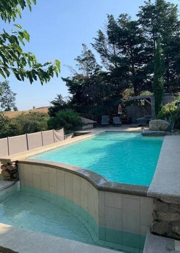une piscine avec de l'eau bleue dans une cour dans l'établissement Villa spacieuse -Vue exceptionnelle- Piscine, à Saint-Romain-de-Lerps