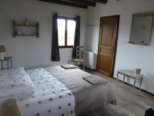 ein Schlafzimmer mit einem großen weißen Bett und einem Fenster in der Unterkunft Villa charmante dans les vergers de Normandie avec piscine privée. in Épinay