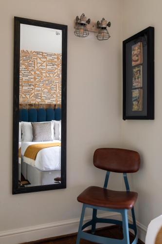 a mirror and a chair in a room with a bed at The Pilot Inn in London