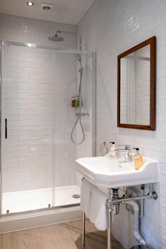 a white bathroom with a sink and a shower at The Pilot Inn in London