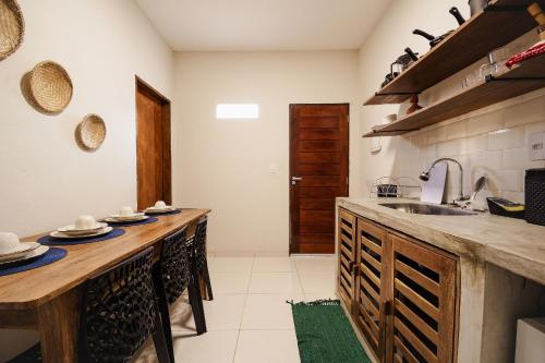 a kitchen with wooden counters and a sink at Flat 01 · Flats Japaratinga1- 200m da praia cozinha completa in Japaratinga