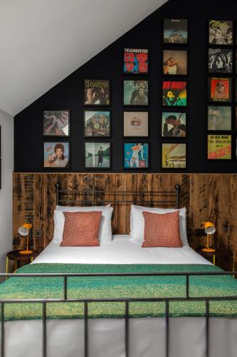 a bedroom with a bed and some pictures on the wall at The Pilot Inn in London
