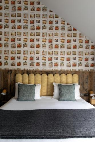 a bedroom with a large bed with a padded headboard at The Pilot Inn in London