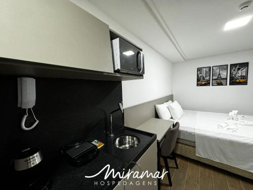 a small hotel room with a bed and a phone at Move - Tambaú in Tambaú