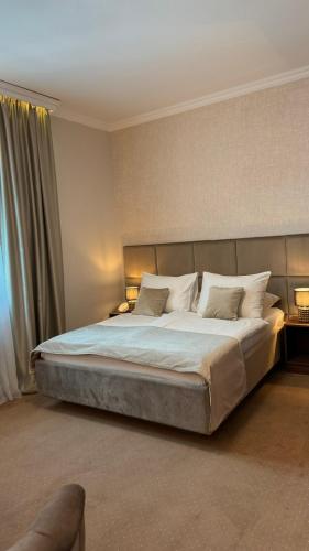 a bedroom with a large bed with white sheets and pillows at Hotel Vidović in Banja Luka