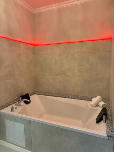 a bath tub in a bathroom with red lighting at Hotel Vidović in Banja Luka