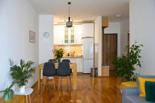 a kitchen and living room with a table and chairs at Apartman Ivice in Gornji Milanovac