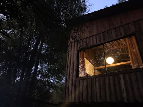 a window of a cabin with a light in it at Cabaña Doña Teresa 5 Huéspedes in Tigre