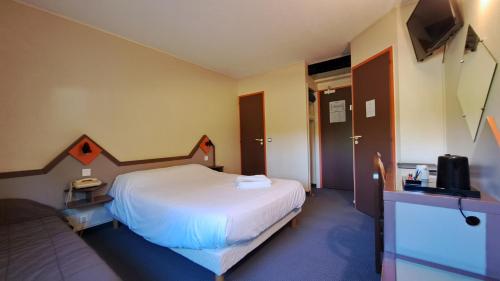 a hotel room with a bed and a television at Abor Hôtel, Mont de Marsan in Saint-Pierre-du-Mont