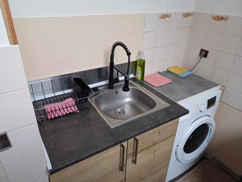 - un comptoir de cuisine avec évier et lave-linge dans l'établissement Appartement indépendant Proche Paris, Roissy CDG, Astérix, Disneyland, à Mitry-Mory