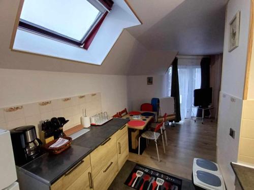 - une cuisine avec une lucarne au plafond, une table et des chaises dans l'établissement Appartement indépendant Proche Paris, Roissy CDG, Astérix, Disneyland, à Mitry-Mory