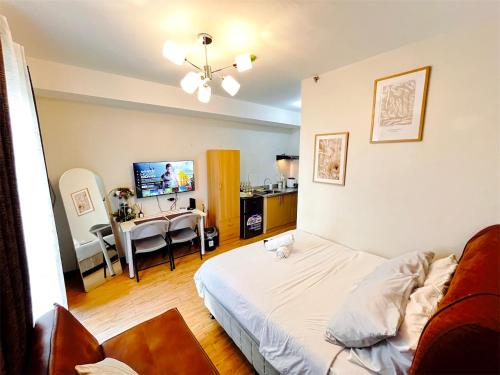 a living room with a bed and a dining room at Cozy Studio with Balcony in Mesaverte near SM Downtown 4pax max with Free Pool & Netflix in Cagayan de Oro