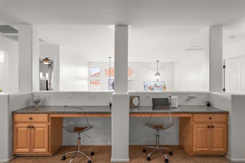 cocina con encimera y 2 taburetes en The Gem Getaway Pool Gameroom Gym by Relaxtay, en Casa Grande