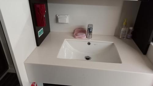 a white bathroom sink in a white counter top at 인천공항 운서역 스카이탑 레지던스 호탤 in Incheon
