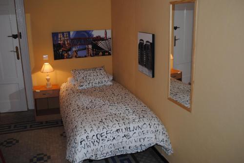 a bedroom with a bed and a mirror at Pensión Santa Paula in Málaga