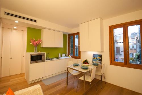 a kitchen with a table with chairs and a microwave at Ca' Venissa in Venice