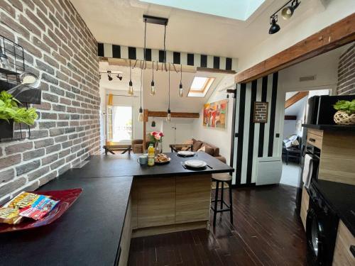 Il dispose d'une cuisine et d'un salon avec un mur en briques. dans l'établissement TEA&CHILL - Brooklyn - at the foot of the RER B, à Aulnay-sous-Bois
