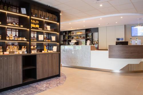 a bar in a hotel room with a counter at Brit Hotel Caen Nord - Mémorial in Caen