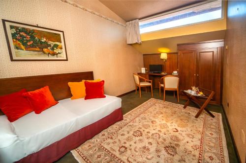 a hotel room with a bed and a table and a desk at Grand Hotel Bastiani in Grosseto